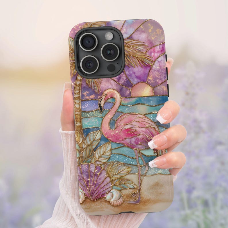 Puede incluir: Funda de tel&eacute;fono con un flamenco rosa sobre una escena de playa con puesta de sol, palmera y conchas marinas. La funda tiene un efecto de vidriera con detalles dorados y un acabado texturizado.