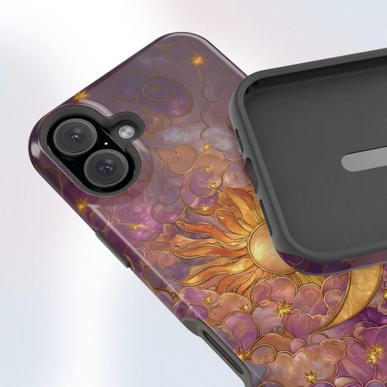 May include: A phone case with a celestial design. It features a sun, moon, stars, and clouds in purple, gold, and orange. The case has a glossy finish and a black interior.