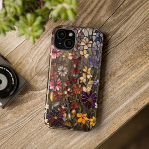 May include: A colourful phone case with a stained glass design featuring a variety of flowers in shades of red, yellow, purple, and blue.