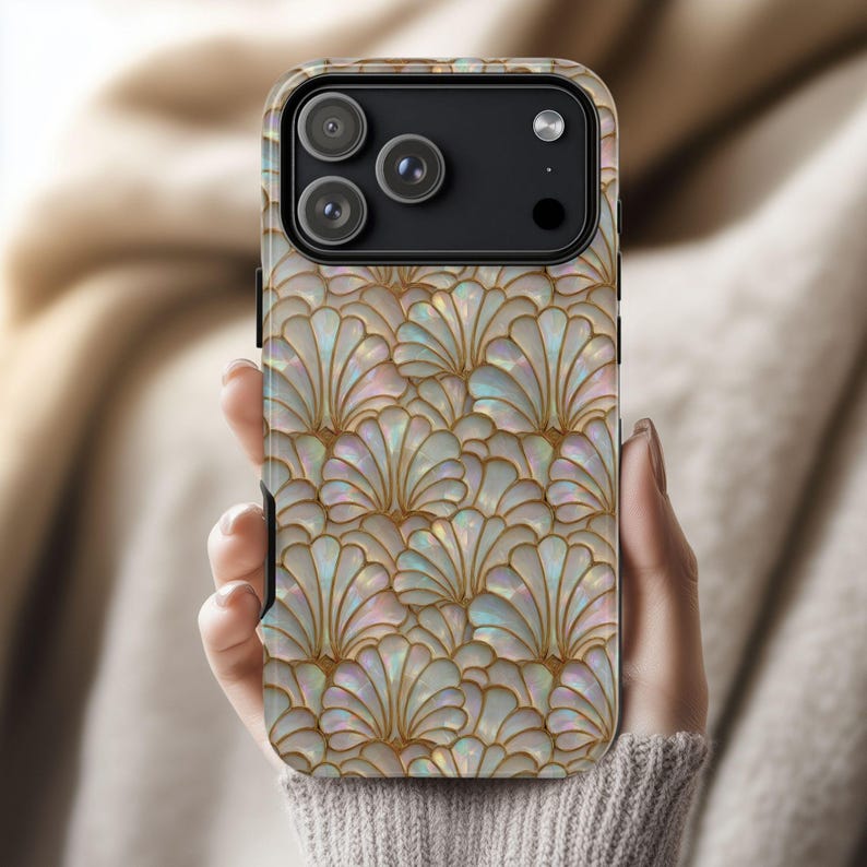 May include: A smartphone case with a pearlescent, fan-shaped pattern in shades of white, gold, and iridescent colors. The case has a black camera module with three lenses.