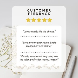 May include: A white card with customer feedback, gold stars, and text. The text includes phrases like "Looks exactly like the photos" and "Love my new phone case." The card is decorated with floral elements.