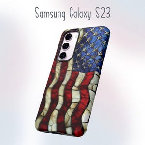 May include: A Samsung Galaxy S23 phone case featuring a mosaic American flag design. The case has a red, white, and blue color scheme, with a textured appearance. The top portion displays a blue field with white stars, while the bottom has red and white stripes.