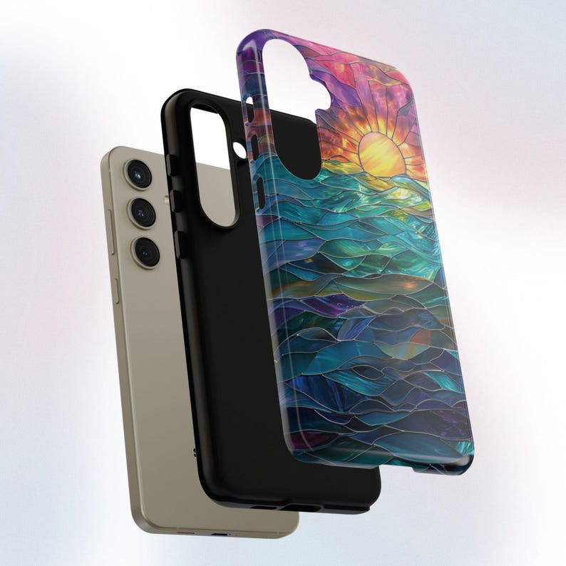Pu&ograve; includere: Una custodia per telefono con un designo in vetro colorato di un tramonto sull'oceano. La custodia &egrave; nera e ha un bordo rialzato attorno all'obiettivo della fotocamera.