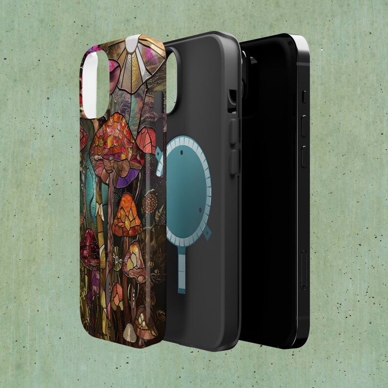 May include: A phone case with a colorful stained glass design featuring mushrooms and a geometric pattern. The case is black and has a clear back.