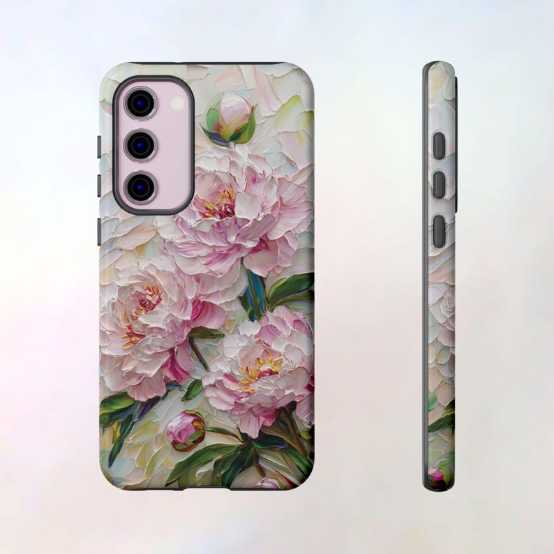 K&ouml;nnte beinhalten: Eine Handyh&uuml;lle mit einem Blumendesign mit rosa Pfingstrosen auf wei&szlig;em Hintergrund. Die H&uuml;lle hat einen Ausschnitt f&uuml;r die Kamera.