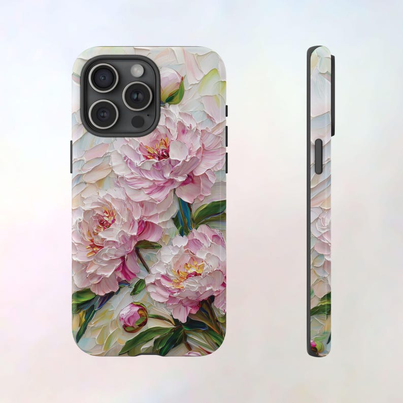 K&ouml;nnte beinhalten: Eine Handyh&uuml;lle mit einem Blumendesign mit rosa Pfingstrosen auf wei&szlig;em Hintergrund. Die H&uuml;lle hat einen schwarzen Kameraausschnitt und einen schwarzen Rand.