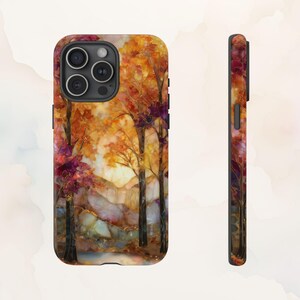 May include: A phone case featuring a vibrant autumn landscape. The design showcases trees with orange and red foliage, a light-filled sky, and a hint of a stream. The case's side also displays the colorful design.