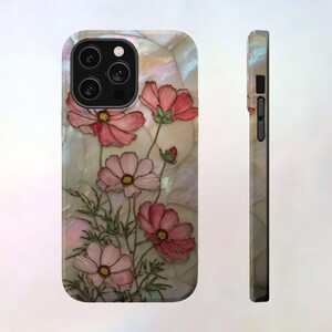 May include: A phone case featuring a floral design with pink cosmos flowers and green leaves. The case has a pearlescent background and a black camera module. The side view shows the case's slim profile.