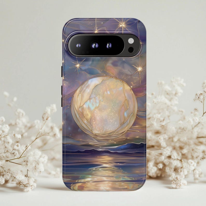 Puede incluir: Una funda de tel&eacute;fono con un dise&ntilde;o celestial. Presenta una gran luna brillante y estrellas sobre un fondo azul oscuro y p&uacute;rpura. La obra de arte representa un paisaje sereno con agua que refleja la luz de la luna. La funda tiene un acabado brillante.