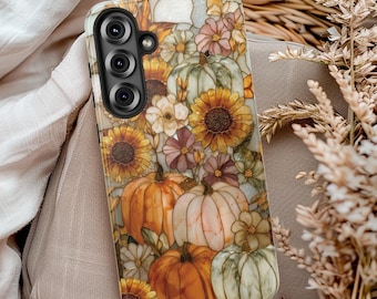 Può includere: Una custodia per smartphone con un vivace motivo in stile vetrata raffigurante zucche arancioni e verde pallido, intervallate da girasoli gialli e piccoli fiori color malva. La custodia presenta un ritaglio nero per tre obiettivi fotografici.