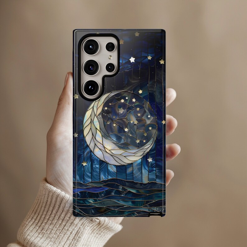 Puede incluir: Una funda para tel&eacute;fono con un dise&ntilde;o de mosaico azul y blanco que presenta una luna creciente y estrellas. La funda tiene un recorte para el objetivo de la c&aacute;mara.