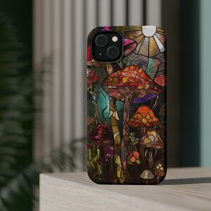 May include: A colorful phone case with a stained glass design of mushrooms in shades of red, orange, yellow, green, and blue.