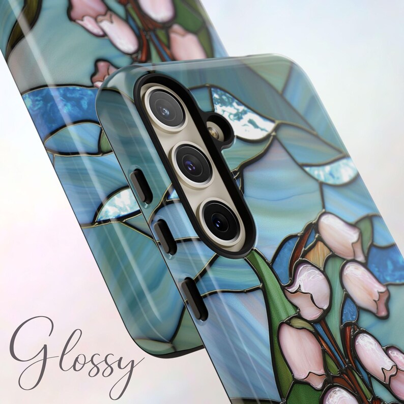 Pu&ograve; includere: Una custodia per telefono con un design in vetro colorato con fiori blu, rosa e verdi. La custodia ha una finitura lucida e un ritaglio per la fotocamera.