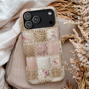 May include: A decorative phone case featuring a patchwork design with floral, leopard print, and solid squares in shades of pink, beige, and white. The case has a lace trim and a black camera module.