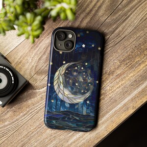Puede incluir: Una funda de tel&eacute;fono azul y dorada con un dise&ntilde;o de luna creciente y estrellas. La luna est&aacute; hecha de un mosaico de azulejos de diferentes colores.