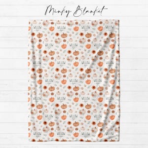 Personalized fall pumpkin minky blanket laid flat showing full watercolor pumpkin and autumn floral repeat pattern with custom name from Twinklette