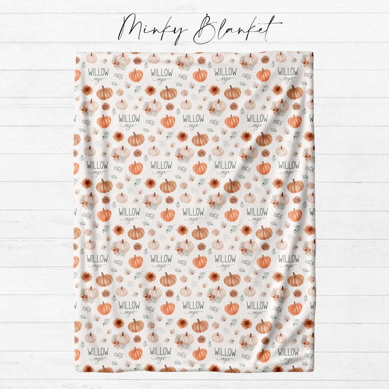 Personalized fall pumpkin minky blanket laid flat showing full watercolor pumpkin and autumn floral repeat pattern with custom name from Twinklette