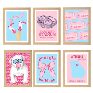 May include: Six framed art prints with a light wood finish. The prints feature a variety of designs, including a stadium, tickets, a bulldog, a bow, and a map of Athens, Georgia, in pink and blue. Text includes "Go Dawgs!" and "Georgia Bulldogs."