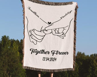 May include: A white woven throw blanket with black text and a graphic of two hands holding each other. The text reads "Jonathan and Madelyn Together Forever 12.04.2024".