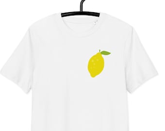 May include: White t-shirt with a yellow lemon graphic on the front.