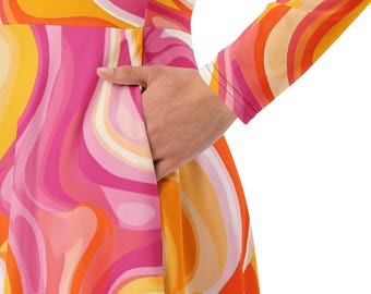 May include: A long-sleeved dress featuring a vibrant, swirling pattern of pink, orange, yellow, and white. The garment includes a fitted bodice with a defined waistline and a side pocket integrated into the seam of the flared skirt.