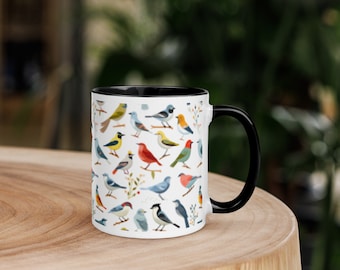 May include: White ceramic mug with a black rim and handle. The mug features a colorful pattern of various birds on a white background.