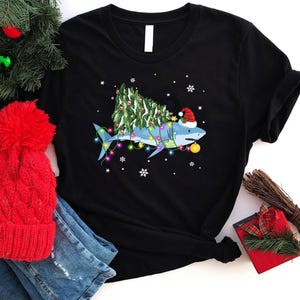 サメの魚のクリスマス ライト ツリー シャツ、メリー シャークマス シャツ、面白いサメのクリスマス シャツ、サメのクリスマス ツリー シャツ