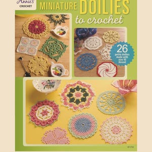 Può includere: Una copertina di libro che presenta una collezione di 26 tovagliette all'uncinetto in miniatura in vari colori e design. Il titolo del libro è "Miniature Doilies to Crochet" e la copertina presenta una varietà di tovagliette, tra cui un design quadrato, rotondo e a spirale.