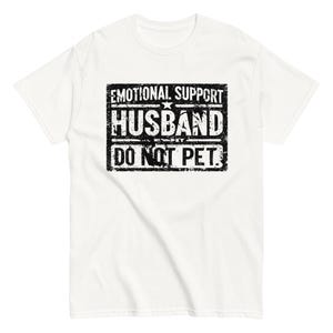 Può includere: Maglietta bianca con una grafica nera invecchiata che dice "Emotional Support Husband Do Not Pet."