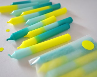 Könnte beinhalten: Ein Set Ombre-Geburtstagskerzen in Gelb- und Türkistönen. Die Kerzen sind in einer durchsichtigen Plastiktüte mit einem gelben Aufkleber verpackt.