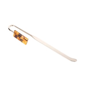 May include: A silver bookmark with a rectangular amber-coloured glass piece at the top.