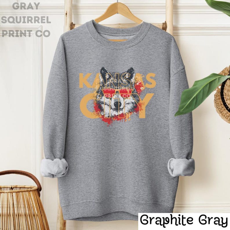 May include: Gray sweatshirt with a wolf wearing sunglasses and the text "Kansas City" in a distressed font.