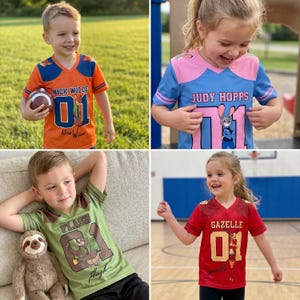 Pu&ograve; includere: Quattro bambini che indossano maglie a tema Zootropolis. Le maglie sono arancioni, blu, verdi e rosse, ognuna con il nome di un personaggio e il numero 01. Le maglie presentano Nick Wilde, Judy Hopps, Flash e Gazelle.
