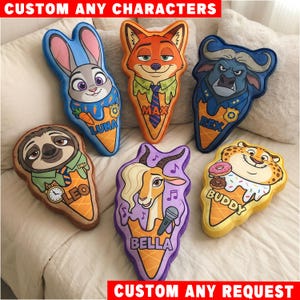 May include: Six plush pillows shaped like ice cream cones, each featuring a different cartoon animal character. The characters include a rabbit, fox, buffalo, sloth, gazelle, and cheetah, with names printed on the cones: Luna, Max, Rex, Leo, Bella, and Buddy.