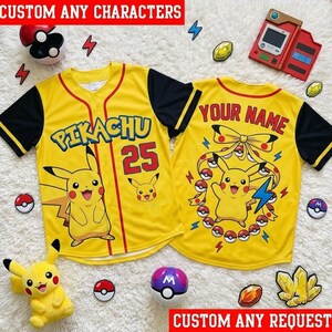 May include: A yellow and black button-down baseball jersey featuring a Pikachu graphic, the text PIKACHU, and the number 25 on the front. The back displays the text YOUR NAME, a Pikachu illustration, and a circular arrangement of Poké Balls.
