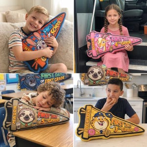 Puede incluir: Una colecci&oacute;n de coloridas almohadas en forma de bander&iacute;n con personajes de dibujos animados y los textos "First Day of School" y "First Day of Grade". Cada almohada presenta un personaje y un grado escolar diferente, incluyendo "First Grade", "4th Grade" y "5th Grade".