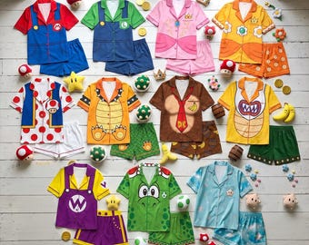 May include: A collection of eleven short-sleeve button-down pajama sets featuring various character designs inspired by the Super Mario franchise, including Mario, Luigi, Princess Peach, Daisy, Toad, Bowser, Donkey Kong, Wario, Yoshi, and Rosalina.