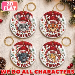 May include: Four round white ceramic ornaments featuring cartoon animal heads wearing Santa hats. Each ornament displays the year 2026 and a name: Mateo, James, Wyatt, or Emma. The designs include a rabbit, fox, bull, and gazelle with festive lights.