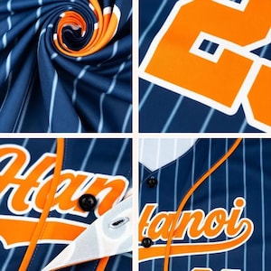 May include: Close-up of a baseball jersey with blue and white pinstripes. The jersey features orange accents and the word "Hanoi" in orange script. The number "2" is visible on the jersey.