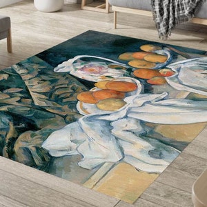 Puede incluir: Una alfombra rectangular con un diseño de naturaleza muerta que representa naranjas y tela blanca. El fondo es azul oscuro con formas abstractas verdes y marrones. Un diseño artístico y colorido para la decoración del hogar.