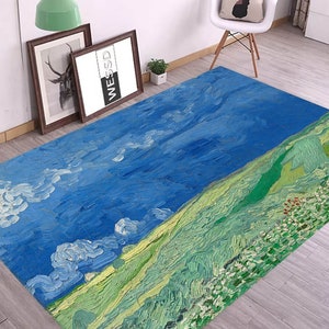 Può includere: Un tappeto blu e verde con un dipinto di un paesaggio con nuvole e colline. Il tappeto ha un effetto a pennellate.