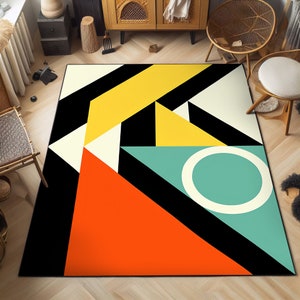 以下が含まれることがあります： 黒、白、黄、オレンジ、ターコイズの幾何学模様の敷物。敷物は、中央に円形があるモダンなデザインです。