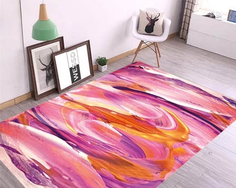 Op de afbeelding: Abstract vloerkleed met roze, oranje en paarse verfstreken. Het kleed heeft een modern en eigentijds ontwerp.