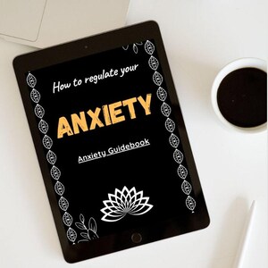 Peut inclure: Une tablette affichant une couverture numérique noire avec le texte blanc How to regulate your, le texte orange ANXIETY et le texte blanc Anxiety Guidebook. Le design présente un motif de fleur de lotus blanche et des bordures de feuilles blanches.