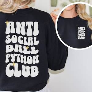 May include: Black sweatshirt with a white graphic that says "Anti Social Ball Python Club" in a retro font. The graphic also includes two gold stars.