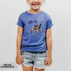 May include: A blue t-shirt with a jumping spider graphic and the text "OH. hi." printed on the front. The shirt is made of a soft, comfortable material and is perfect for everyday wear.