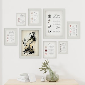 May include: A set of eight black and white framed prints with Japanese calligraphy and English translations. The prints are hung on a white wall with a vase of dried flowers and a stack of books on a wooden table below.