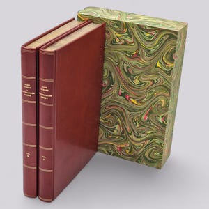 May include: Two red leather-bound books with gold lettering titled "Jane Austen's Novels" in a marbled green box.