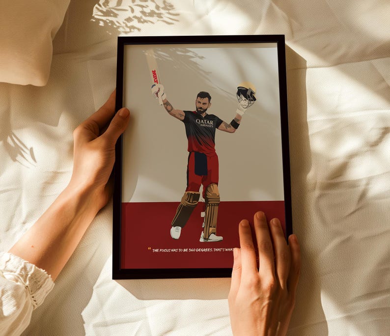 May include: Framed art print featuring a cricket player in a black and red uniform, holding a bat and helmet. The artwork has a minimalist style with a quote at the bottom. The background is a mix of beige and red.