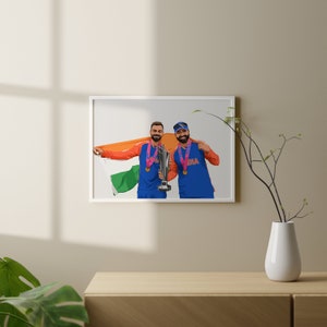 K&ouml;nnte beinhalten: Zwei M&auml;nner in blauen und orangen Sportuniformen halten eine Troph&auml;e und eine indische Flagge. Beide tragen Medaillen um den Hals. Der Mann links h&auml;lt die Troph&auml;e und der Mann rechts h&auml;lt die Flagge.